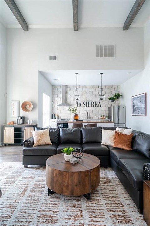 A living room with a black couch and a coffee table.
