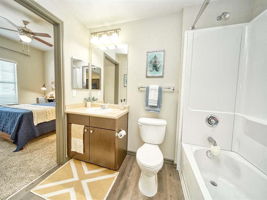 a bathroom with a toilet and a tub and a sink