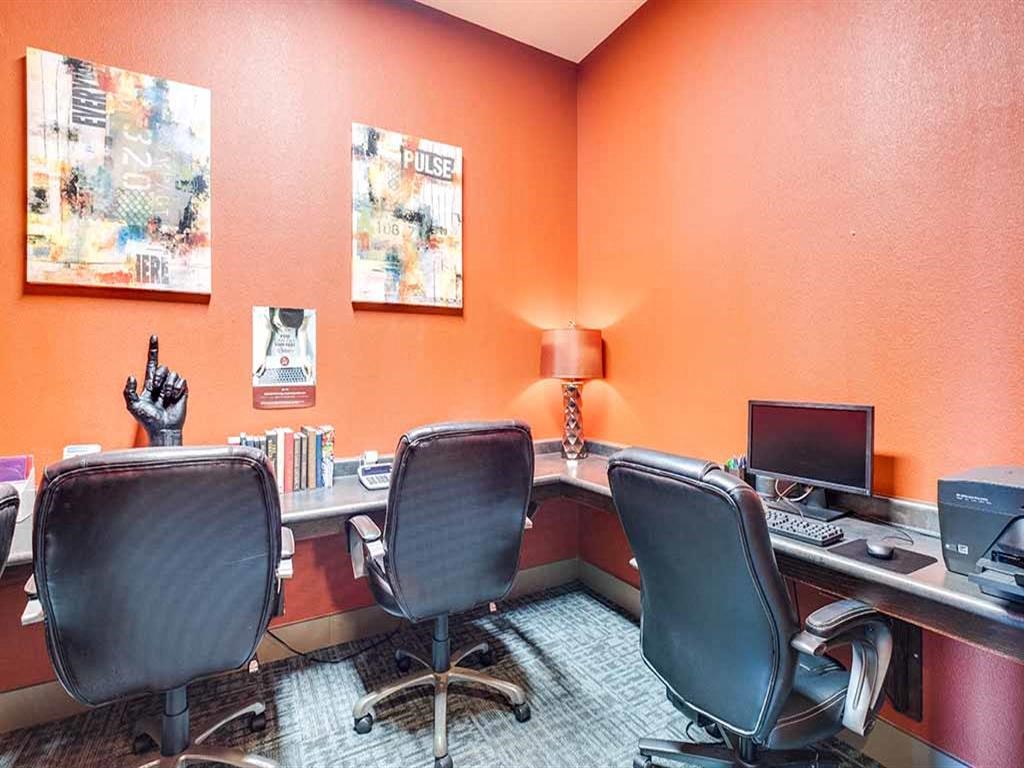 a office with two desks and two chairs and a computer