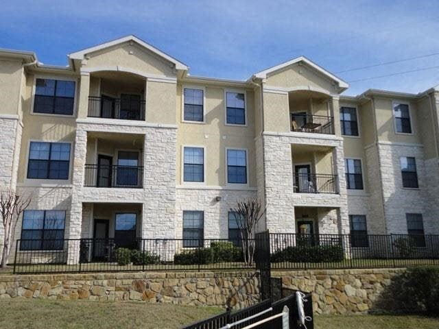 an apartment building with a fence in front of it