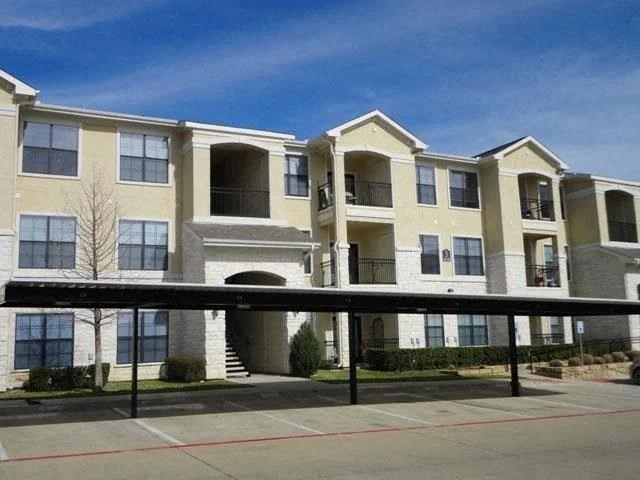 an apartment building with a sidewalk in front of it