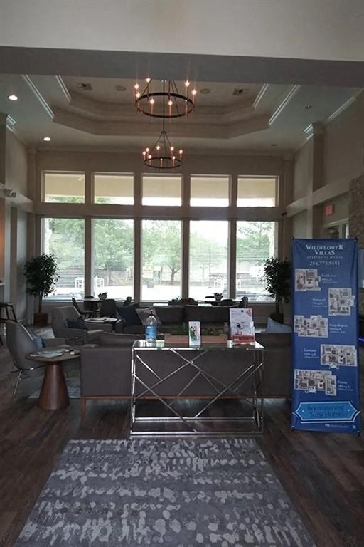 a lobby with a table and chairs and large windows