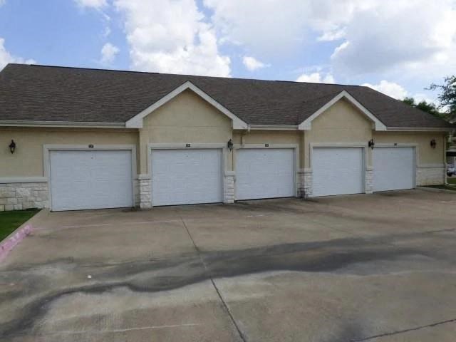 a white house with three garages and a driveway