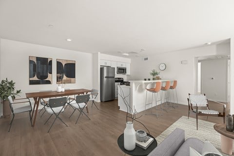 A modern living room with a dining table and chairs.