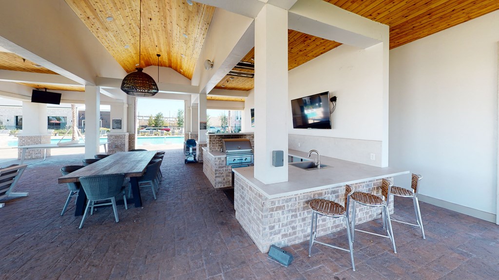 a kitchen and dining area with a television and a pool in the background