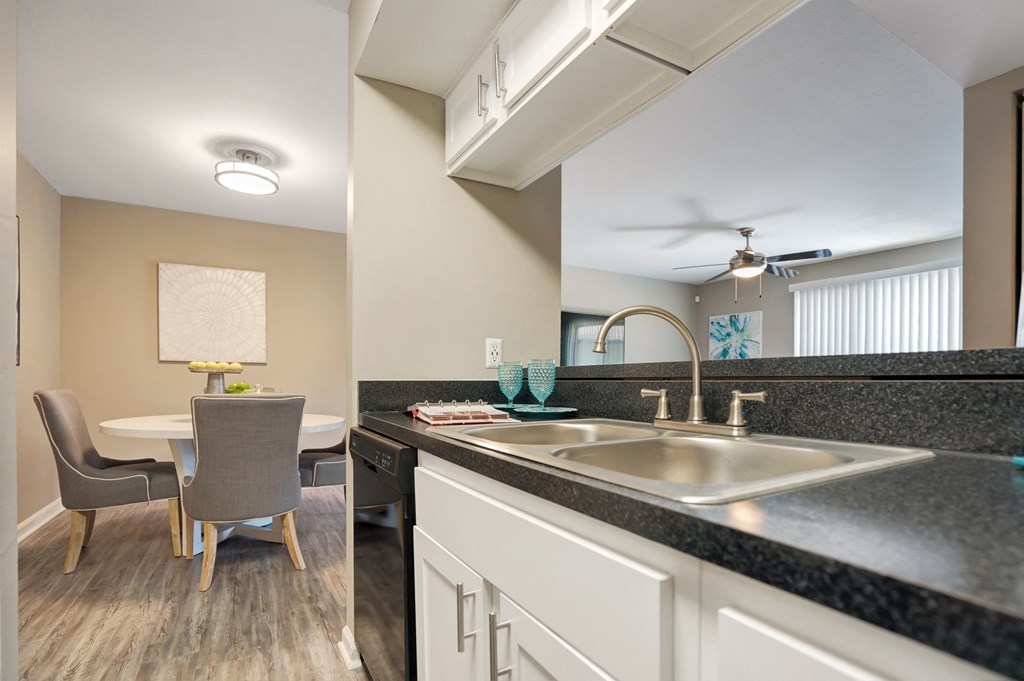 A kitchen with a table and chairs.