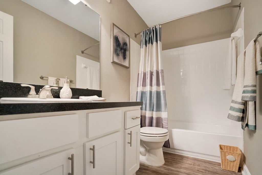 A bathroom with a toilet, sink, and shower.