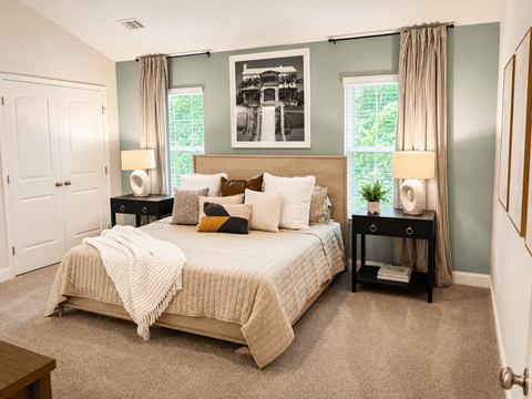 A bedroom with a large bed and a painting on the wall.