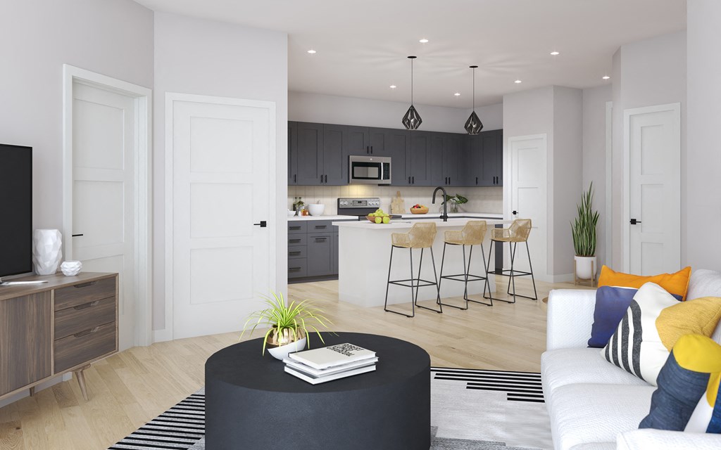 a living area with a sofa coffee table and a kitchen in the background
