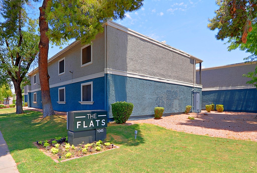 a blue building with a sign that says the flats