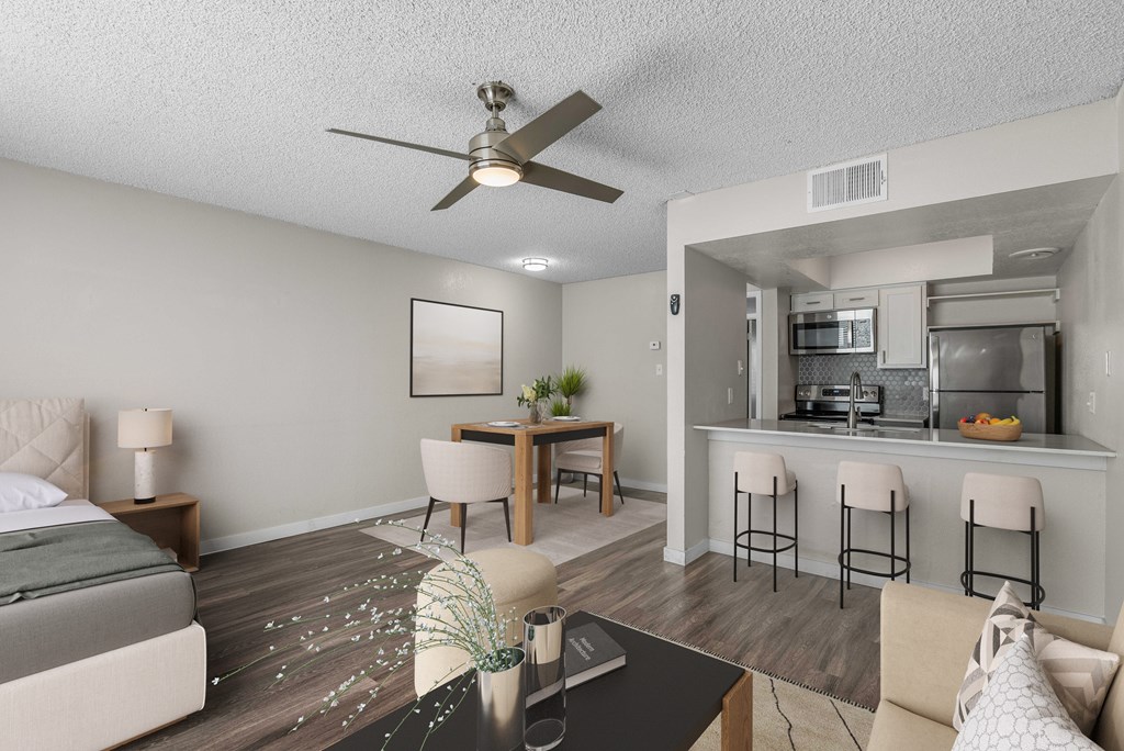 A modern living room with a kitchen area in the background.