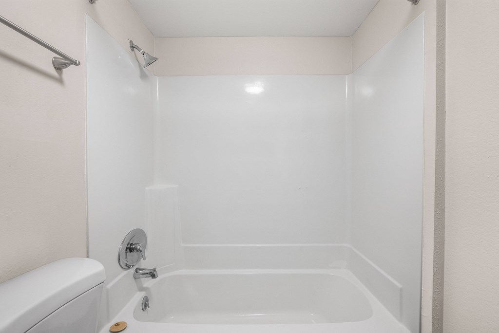 a white bathroom with a tub and a toilet and a sink