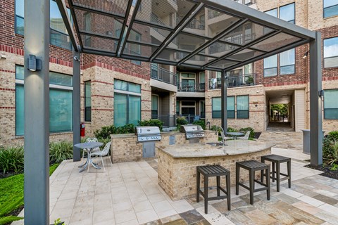 A patio with a table and chairs under a roof.