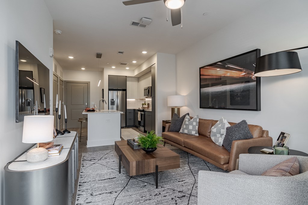 A modern living room with a brown leather couch and a coffee table.