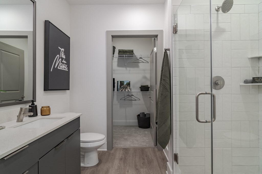 A bathroom with a toilet, sink, and a walk-in shower.