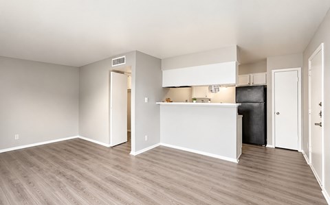 A room with a white counter and a black trash can.