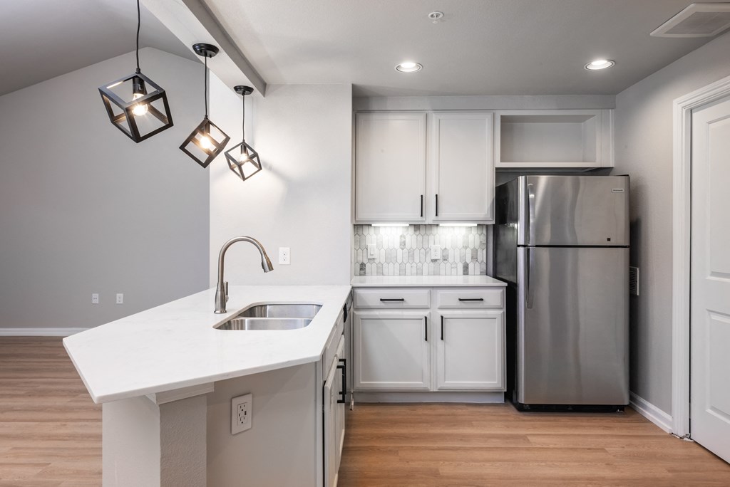 a kitchen with white cabinets and a white counter top