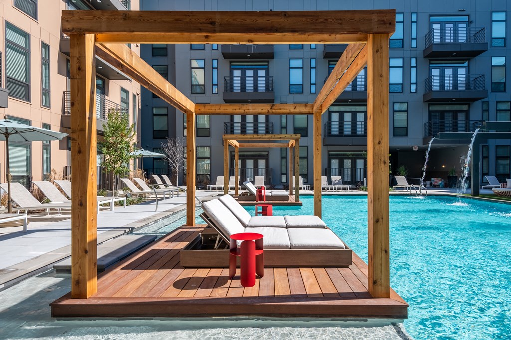 a deck with two lounge chairs and a fire hydrant next to a pool