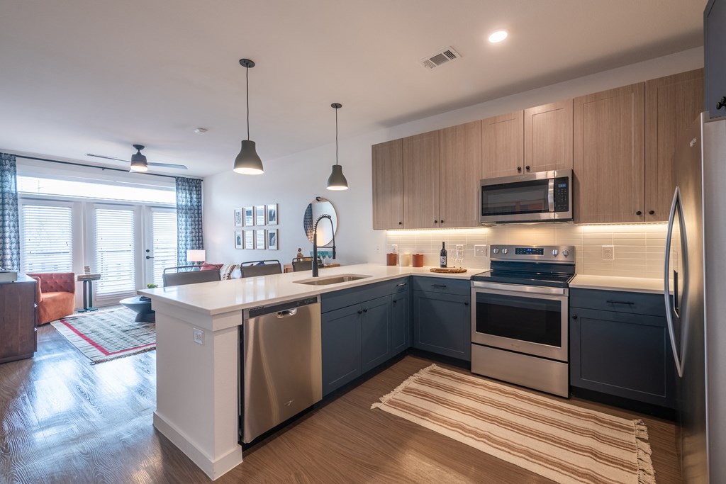 a kitchen with a large island and stainless steel appliances