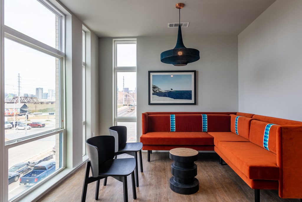 a seating area with a red couch and black chairs