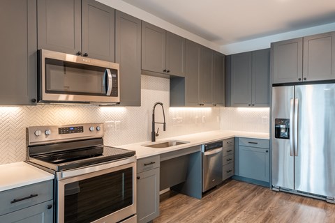 a kitchen with stainless steel appliances and blue cabinets