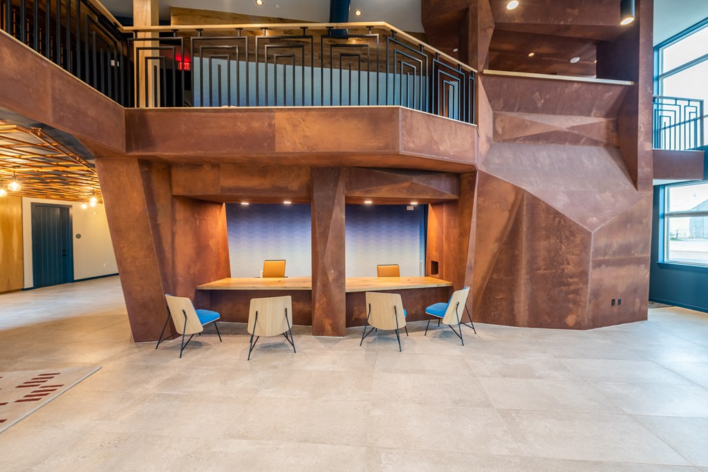 a table and chairs in a large room with a spiral staircase in the background