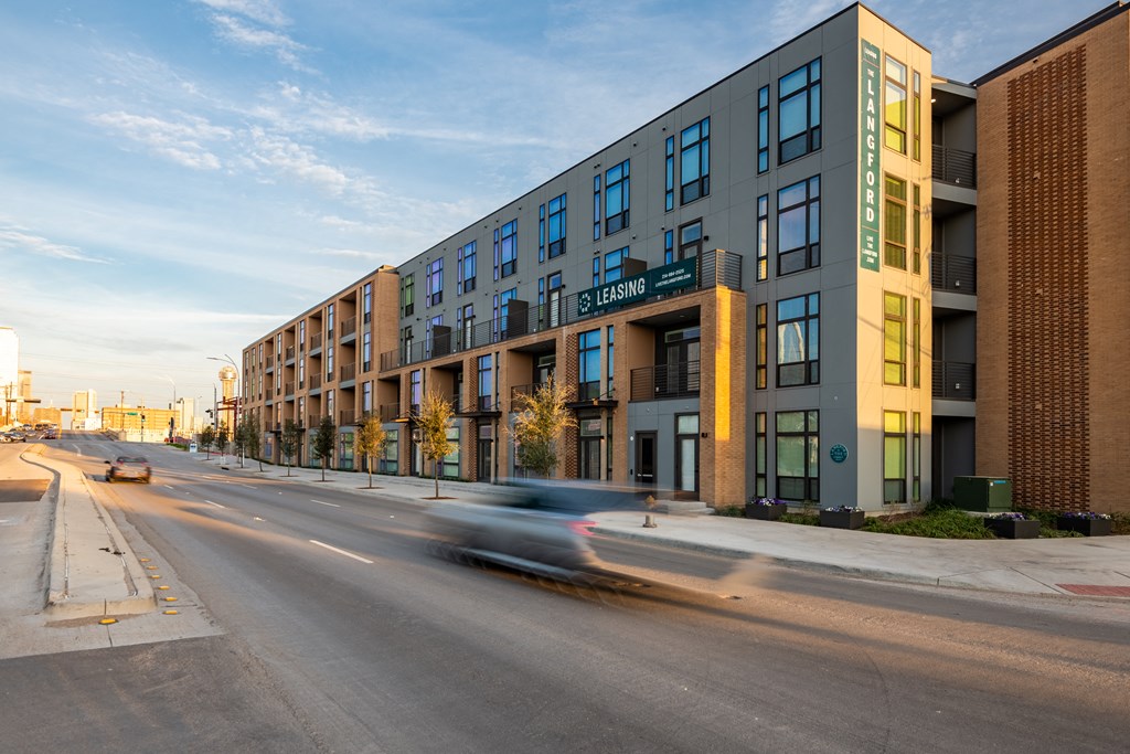 a car drives by a large building on a city street