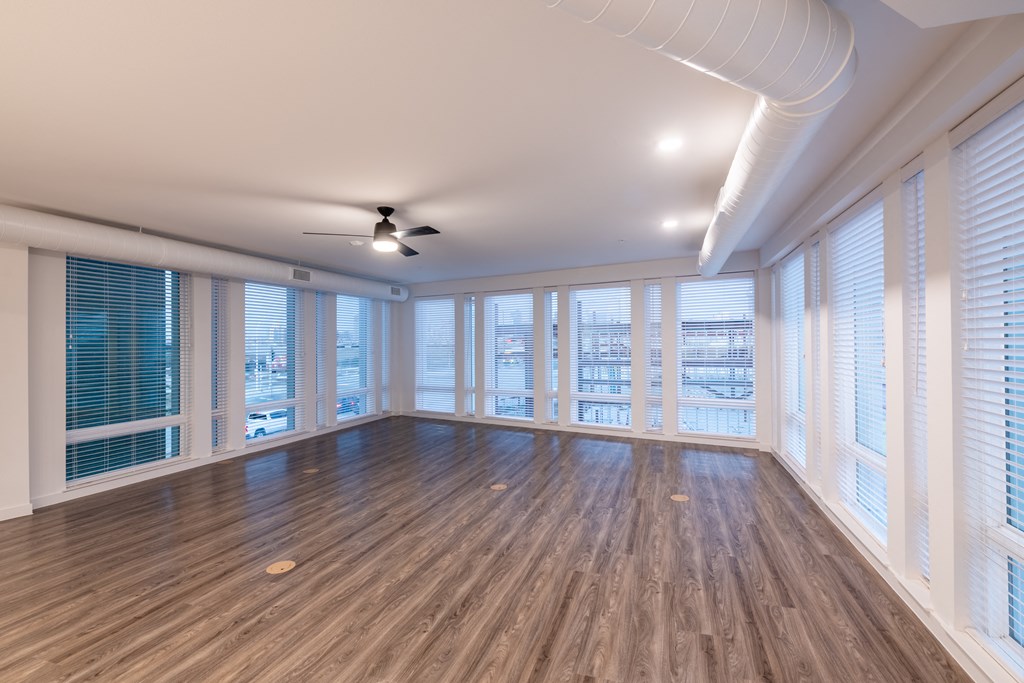 an empty living room with hardwood floors and a ceiling fan