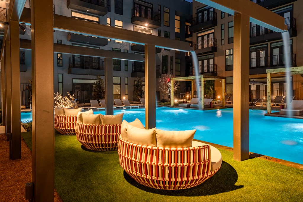 a night shot of the outdoor seating area with the pool in the background