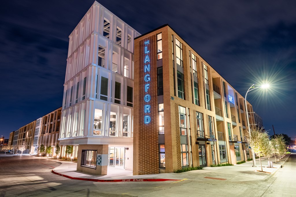a night view of a building with a neon sign that reads welcome