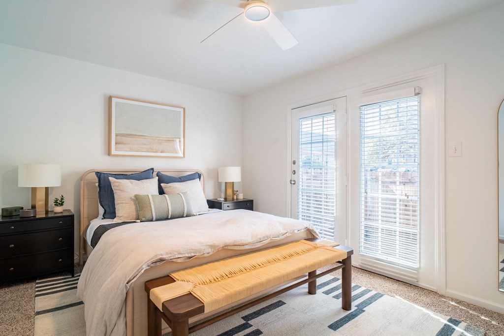 a bedroom with a large bed and two windows