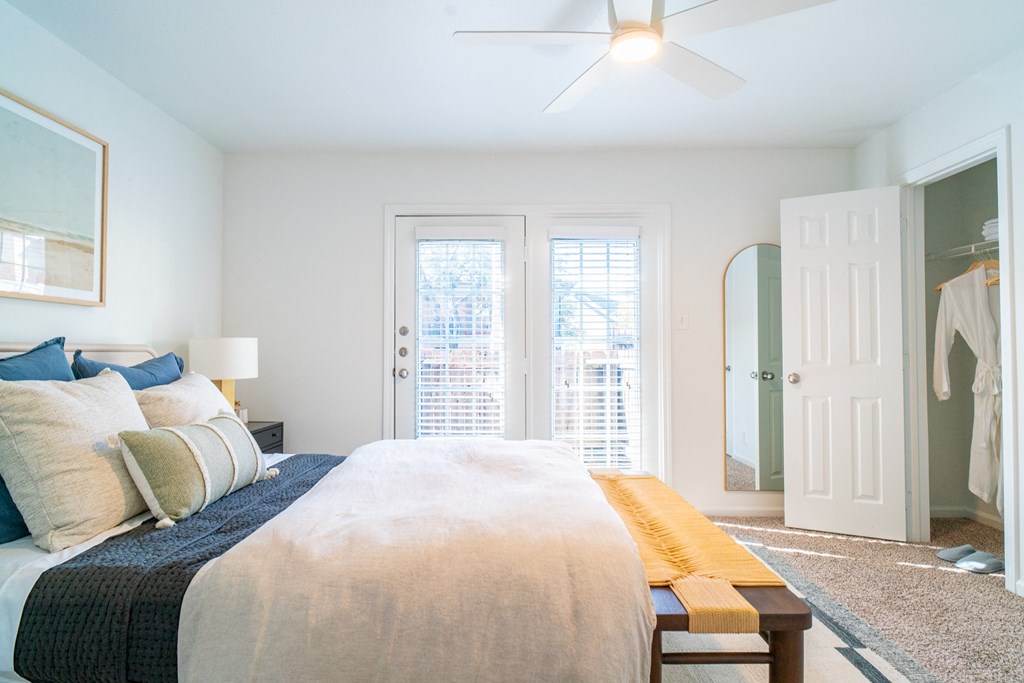 a bedroom with a bed and a closet and a ceiling fan
