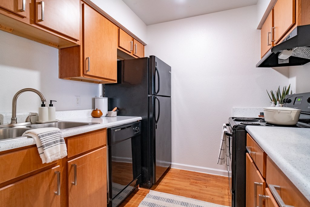 a kitchen with wooden cabinets and a black refrigerator