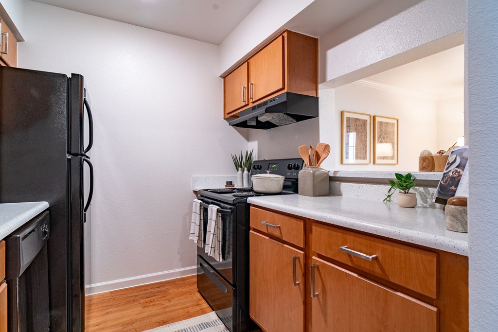 a kitchen with black appliances and wooden cabinets