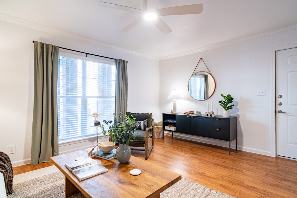 a living room with a ceiling fan and a large window