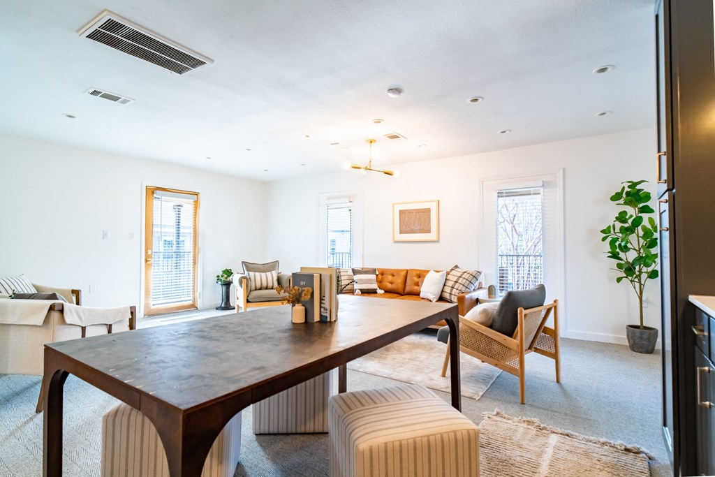 a living room with a large wooden table and a couch