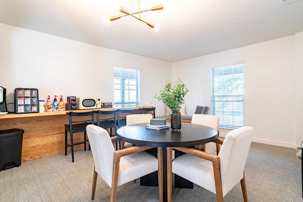 a dining room with a table and chairs and a kitchen