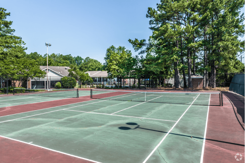 two tennis courts at the whispering winds apartments in pearland, tx