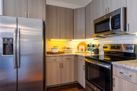 A kitchen with a stainless steel refrigerator and a microwave oven.