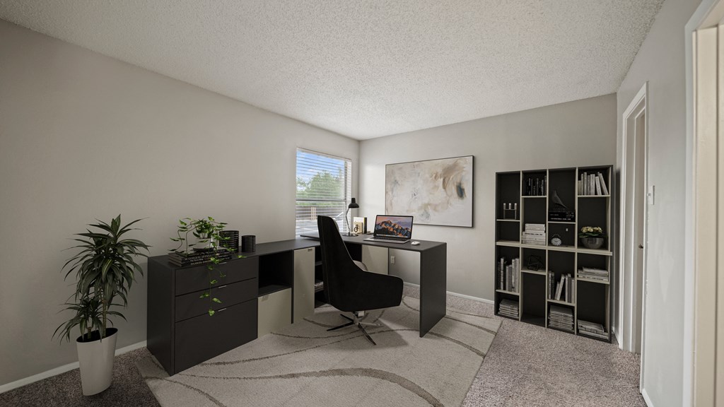 an office with a desk and a chair in a room with a bookcase