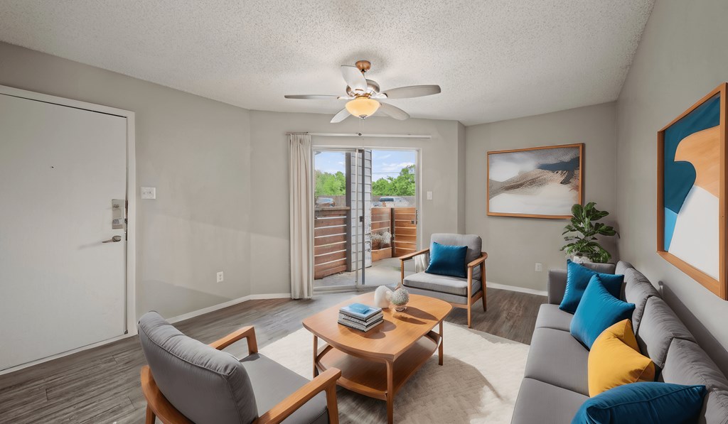 a living room with a couch and a table and a ceiling fan