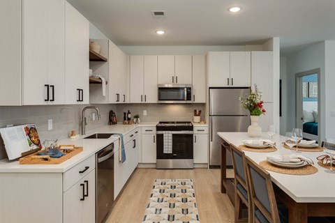 a large kitchen with white cabinets and stainless steel appliances