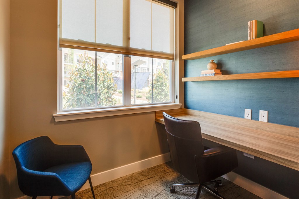 a desk and two chairs in a room with a window