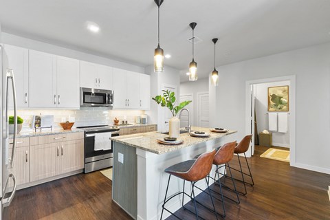 an open kitchen with a large island with three chairs