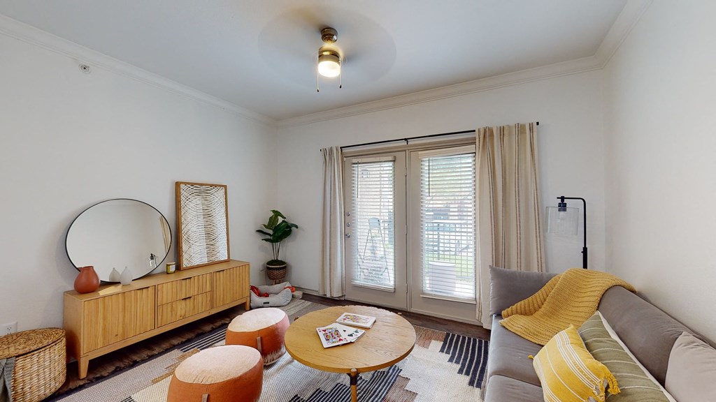 a living room with a couch and a mirror and a window