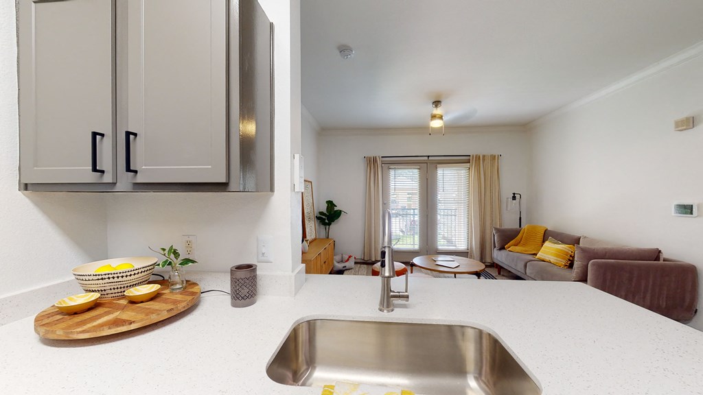 a kitchen with a sink and a living room with a couch