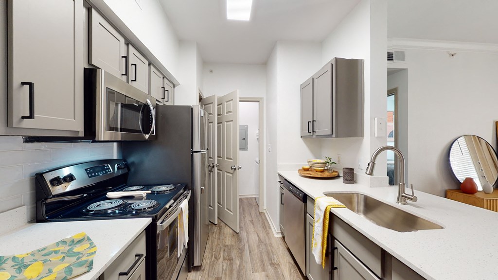 a kitchen with white cabinets and stainless steel appliances and a sink