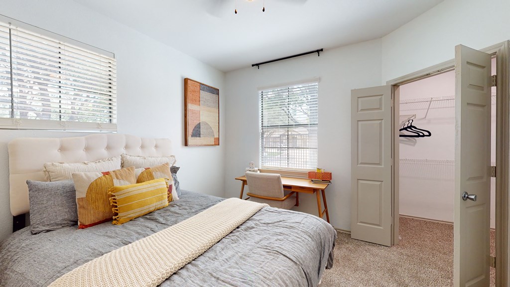 a bedroom with a bed and a desk and a closet