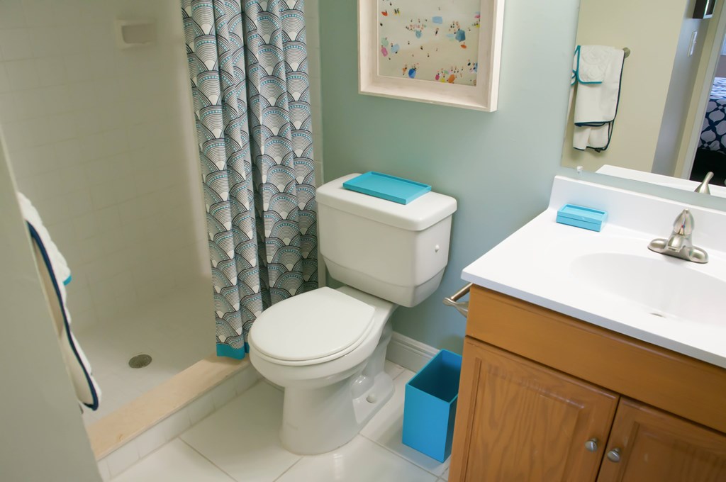 A white toilet sits next to a sink in a bathroom.
