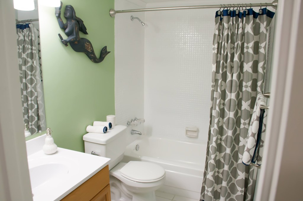 A bathroom with a green wall and a white toilet.